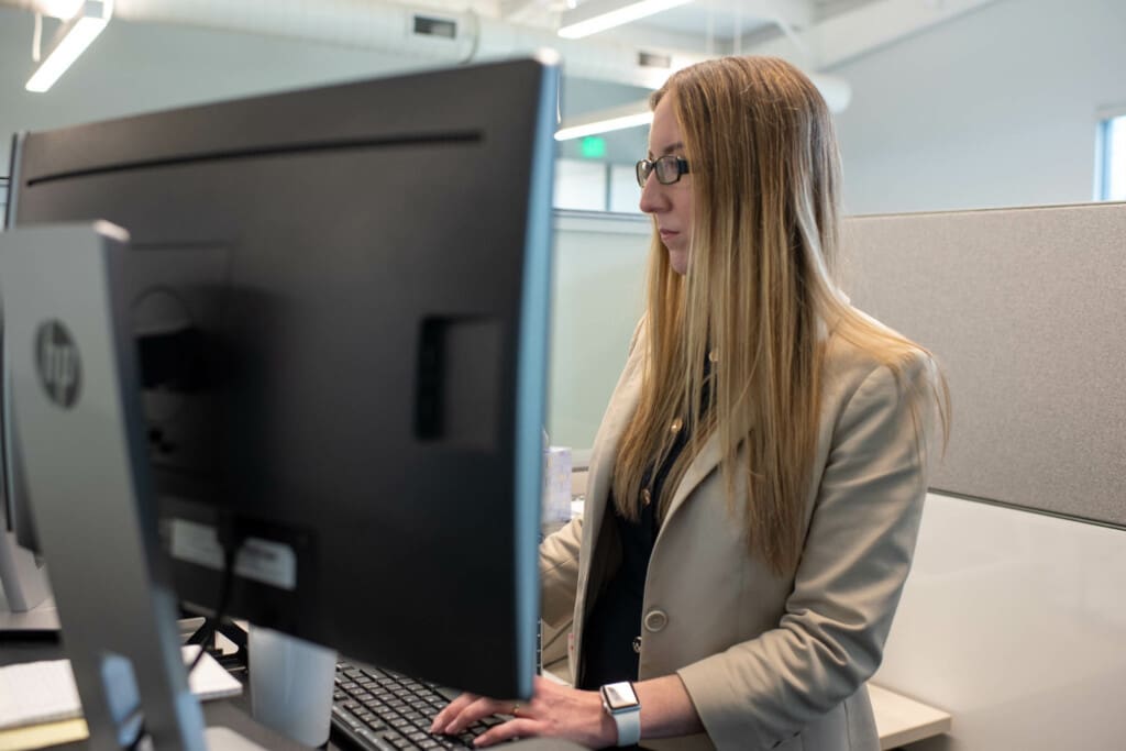 Ascend employee working at a computer at a standing desk